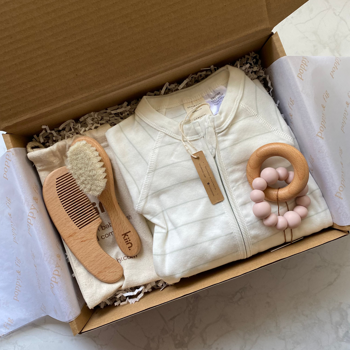 Baby gift box including clothing and baby brush